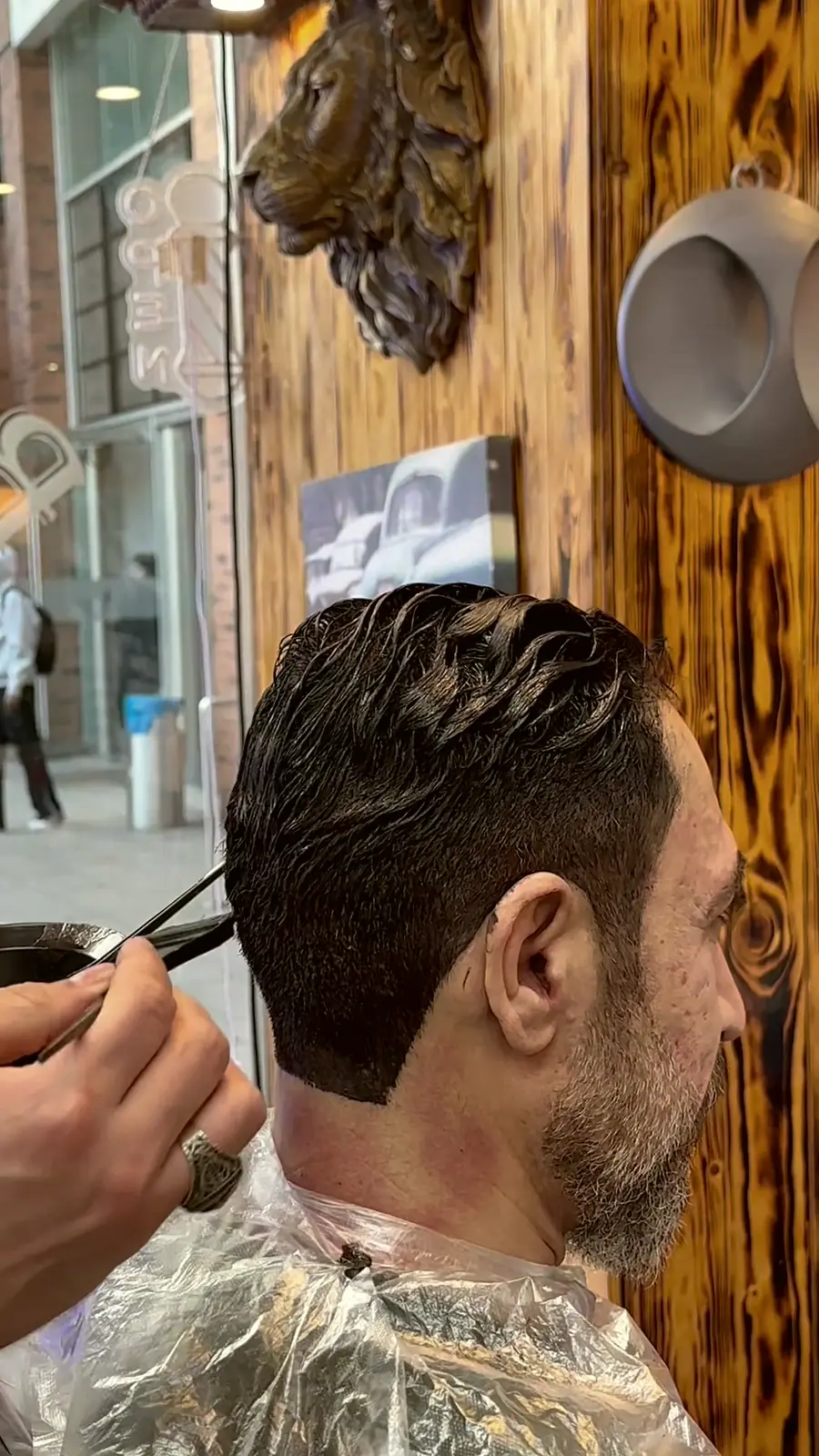 Barbier schneidet mit der Schere den Nacken eines Kunden mit Bart